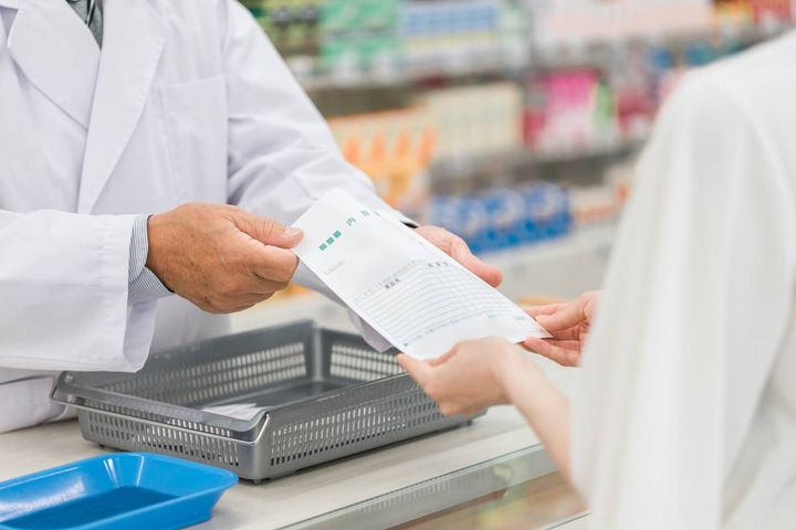 薬を手渡す薬剤師