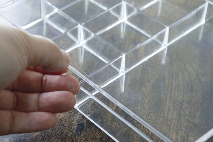 女性の指がクリアケースのフタを開けている様子
