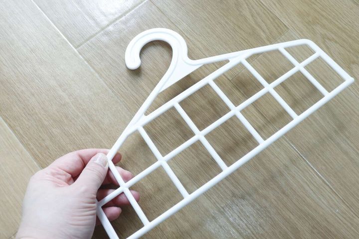 白いメッシュのハンガー部分を手に持つ