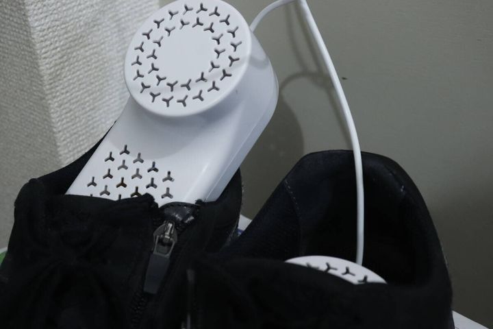 黒い靴の中にUSB式シューズドライヤーの乾燥ユニットをセットしている様子