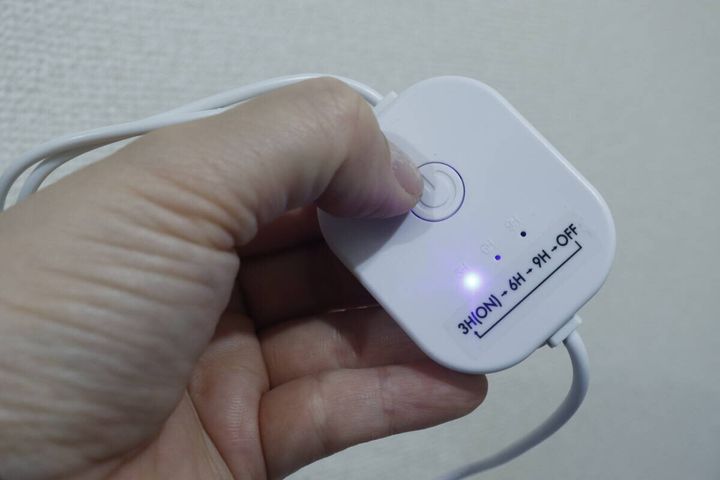 USB式シューズドライヤーのコントローラーのボタンを押し、青いランプが点灯