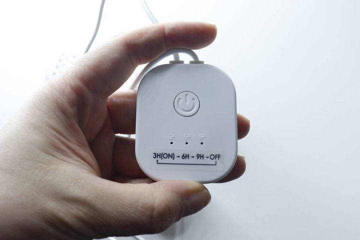 手に持ったUSB式シューズドライヤーのコントローラー。電源ボタンとタイマー表示