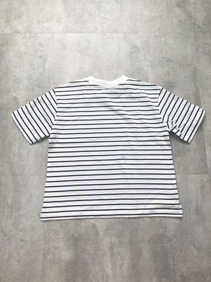 白地に黒の細いボーダー柄Tシャツの背面を平置きした俯瞰写真