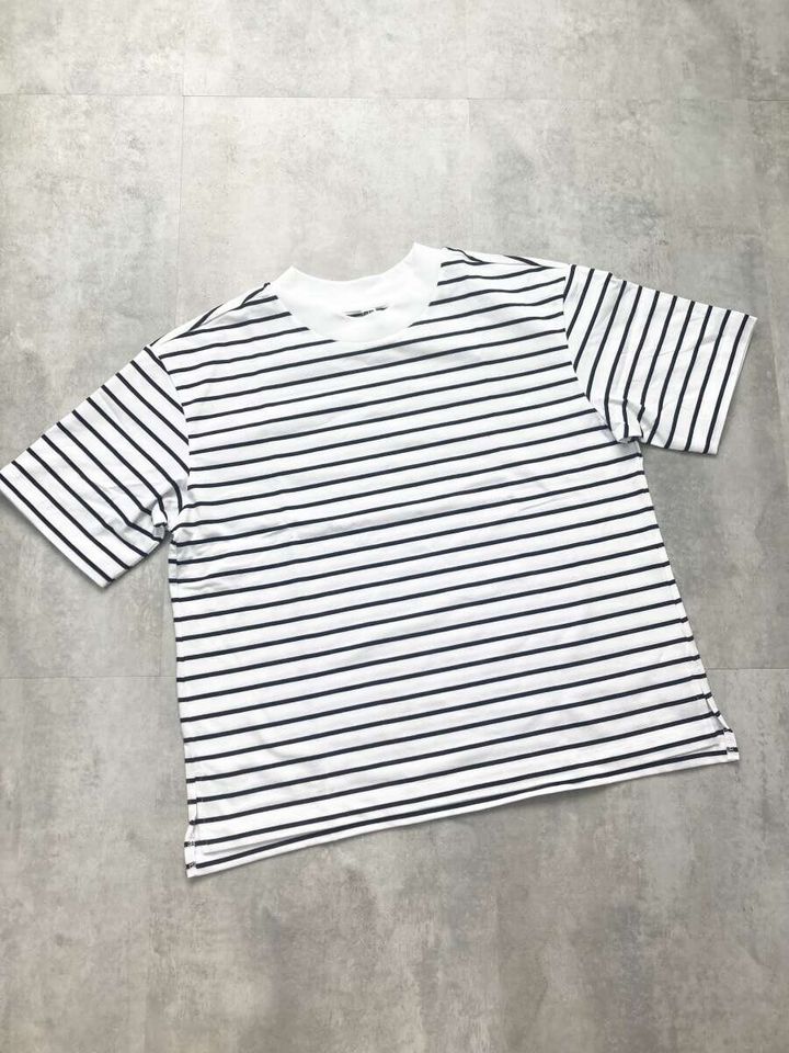 白地に黒の細いボーダー柄Tシャツを平置きした俯瞰写真