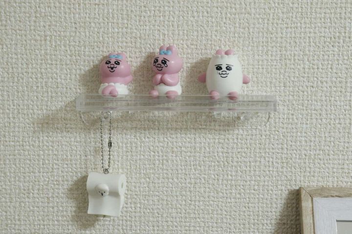 壁に設置されたスタンドに飾られたキャラクターグッズ
