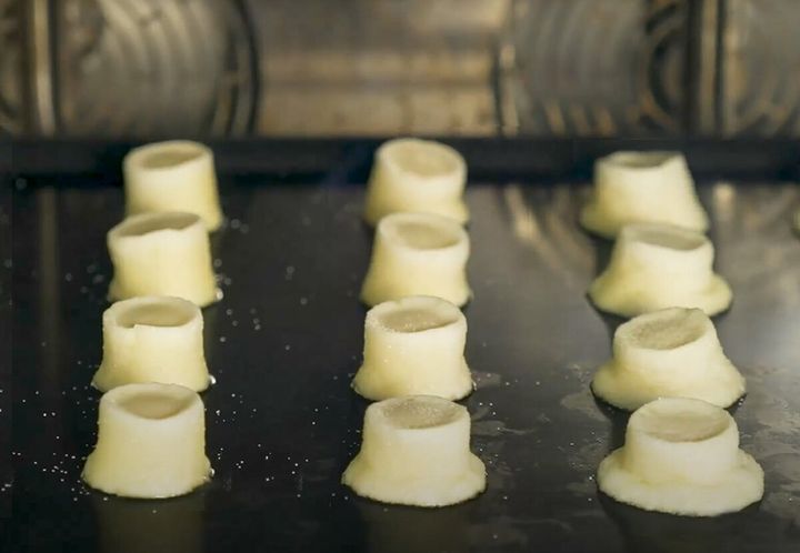 オーブンシートに並べられた王冠のような形のクッキー生地