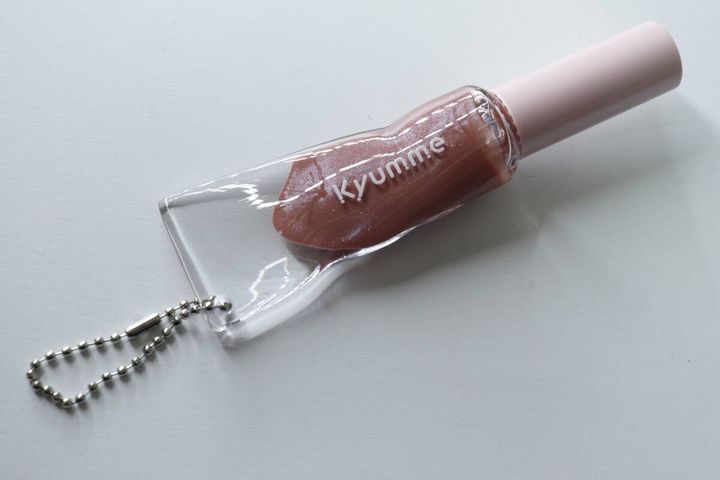 04bシアーレッドのチェーン付きリップグロスが斜めに置かれている