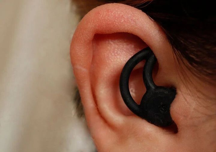 女性の耳に黒いシェル型耳せんが装着されている