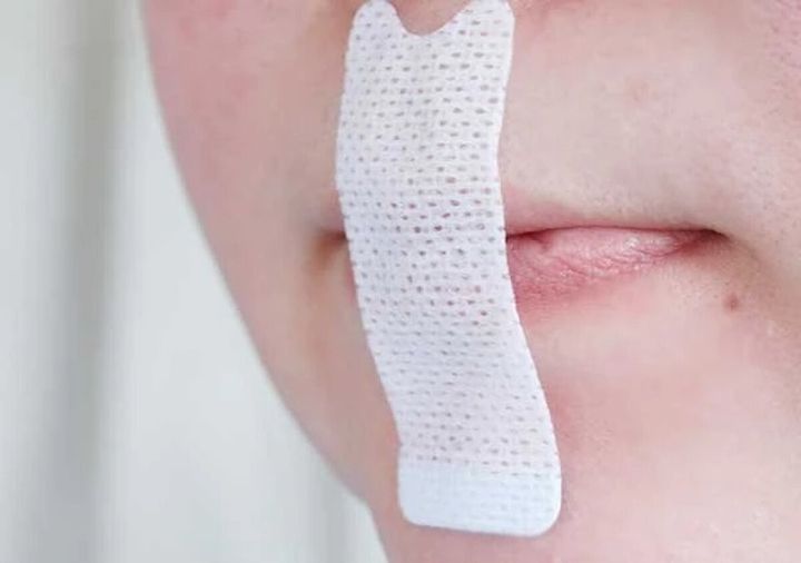 女性の口元に白いマウステープが貼られている