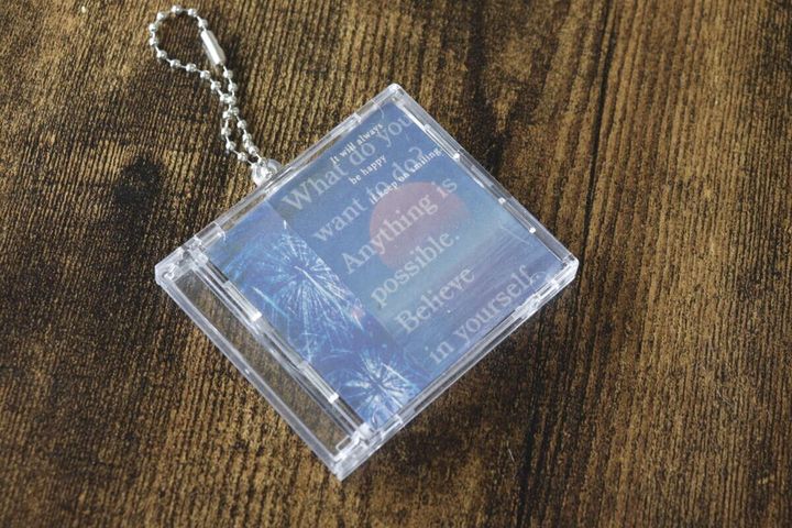 デザインされた紙がセットされたCD風キーホルダー