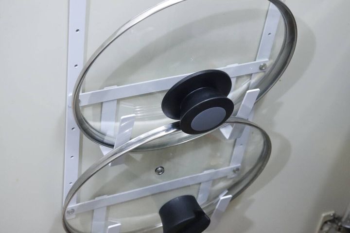扉の裏側に設置されたホルダーにガラス製の鍋ふたが2つ収納されている