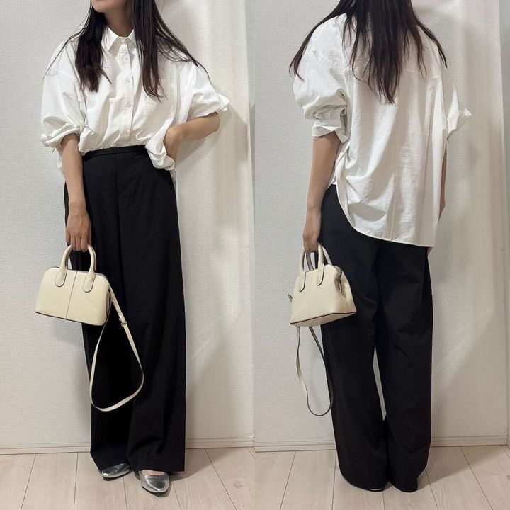 白シャツと黒パンツのオフィスコーデ。女性が白いバッグを持つ