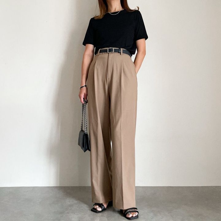 黒いシアーTとベージュワイドパンツの全身コーデ。黒いベルトとサンダル。