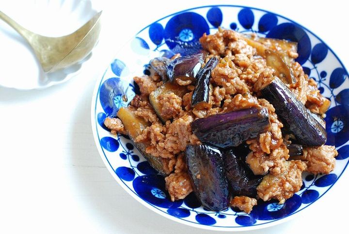 青と白の模様の皿に盛り付けられた、なすとひき肉の味噌ケチャ炒め。横に白い小皿とスプーン
