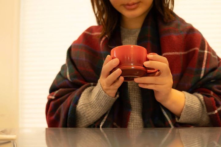 温かい飲み物を飲む女性
