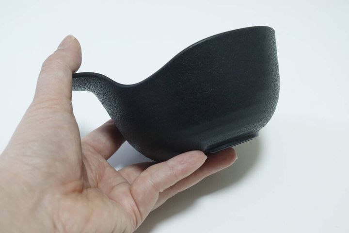 女性の手がダイソーの黒い呑水の縁をしっかり持っている様子