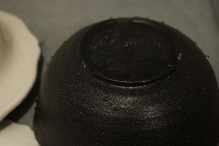 水滴がついたダイソーの黒い呑水の底面、高台の切り欠きが見える