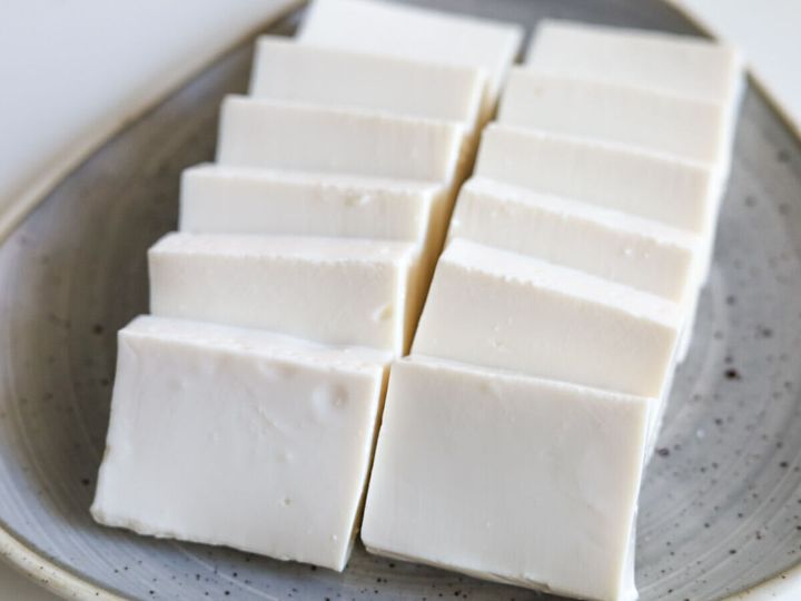 灰色のお皿に、一口大にカットされた白い絹ごし豆腐が並べられている様子