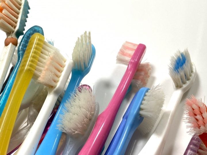 カラフルな使い古しの歯ブラシが多数密集している