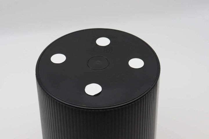黒いゴミ箱の底に白い丸い粘着テープが4箇所貼られている