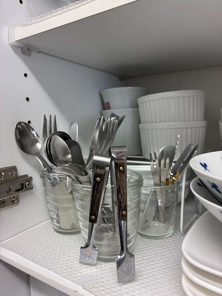 食器棚でガラスカップにカトラリーが複数収納されている