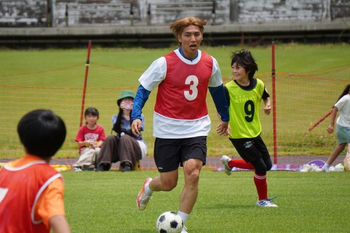 画像: 子どもたちとのミニゲームで、中盤から果敢にボールを持ち運ぶ稲見（写真：白谷遼）