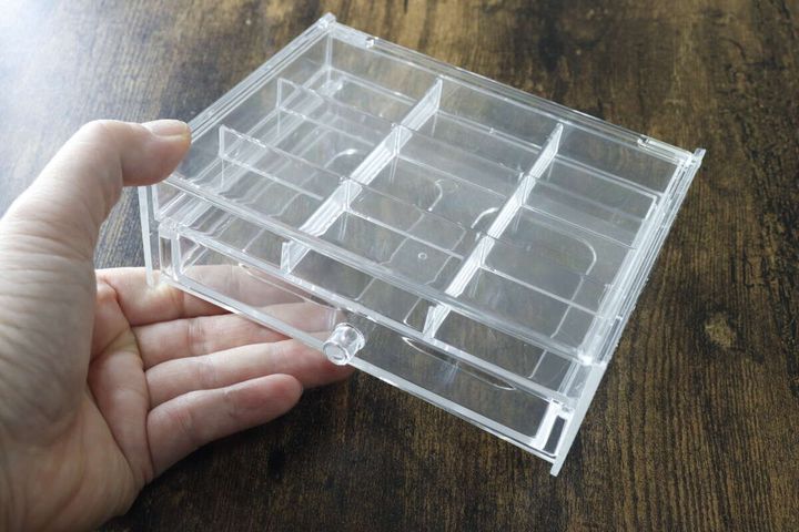 女性の手で持たれたダイソーのクリアなアクセ収納ケース