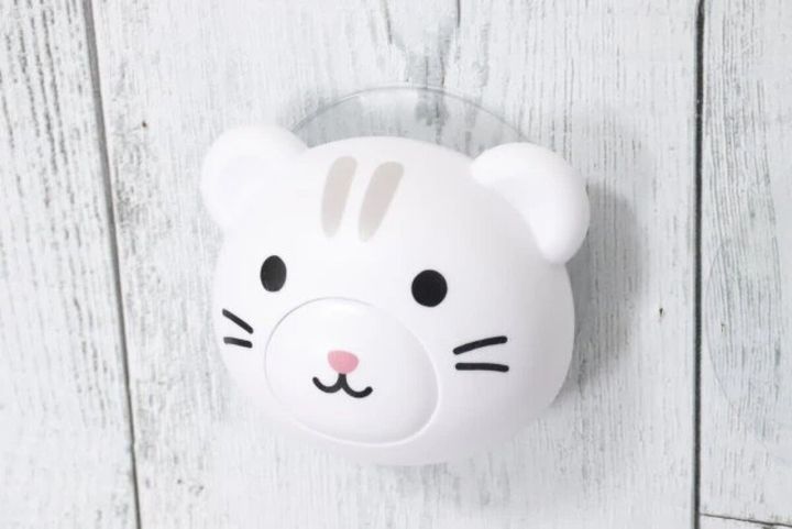 白い壁に設置された猫の顔デザインのフック