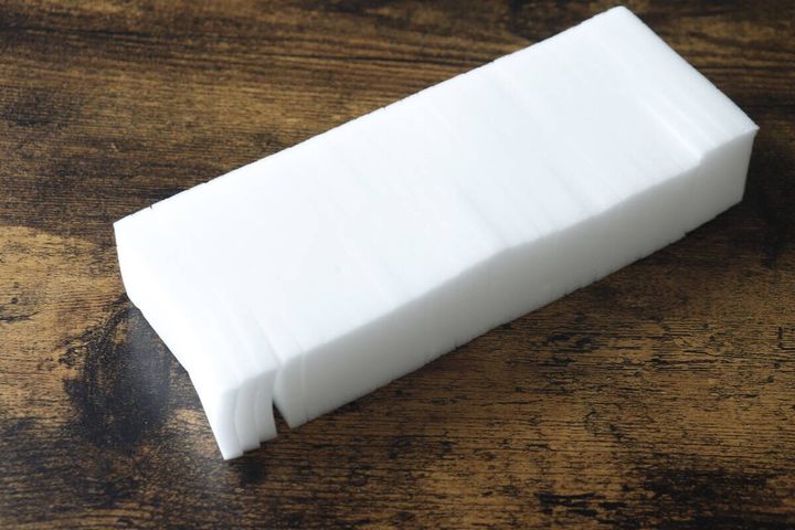 木目のテーブルに置かれた、繋がった状態の白いメラミンスポンジ本体