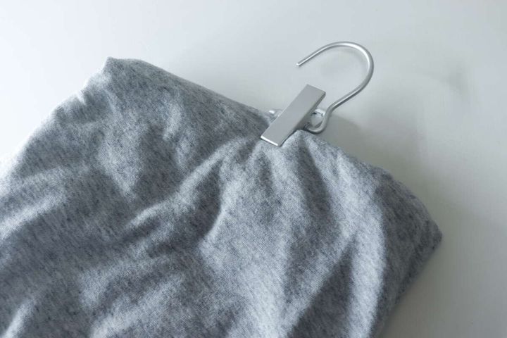 アルミフックピンチでグレーのスウェットパンツのウエスト部分を挟んでいる様子