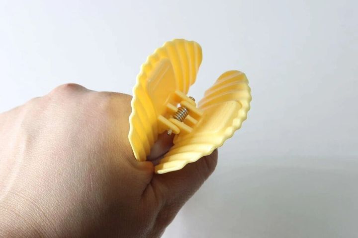 ポテトチップス型の黄色いクリップを大きく開いている