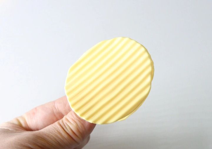 ポテトチップスそっくりの黄色いクリップを指でつまむ