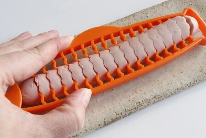 魚型スライサーで魚肉ソーセージを波型にカットする手元
