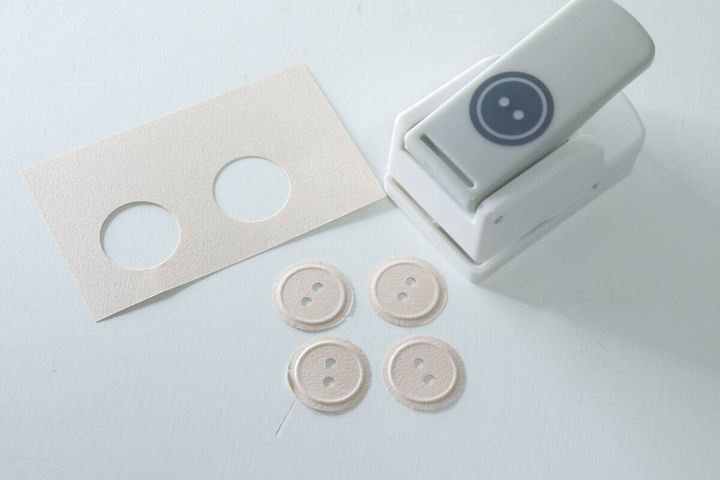 パンチされたボタン型パーツとパンチ後の画用紙