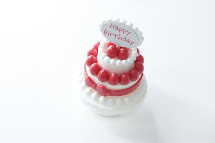 完成した白い二段のいちごケーキに「Happy Birthday」プレートが飾られている