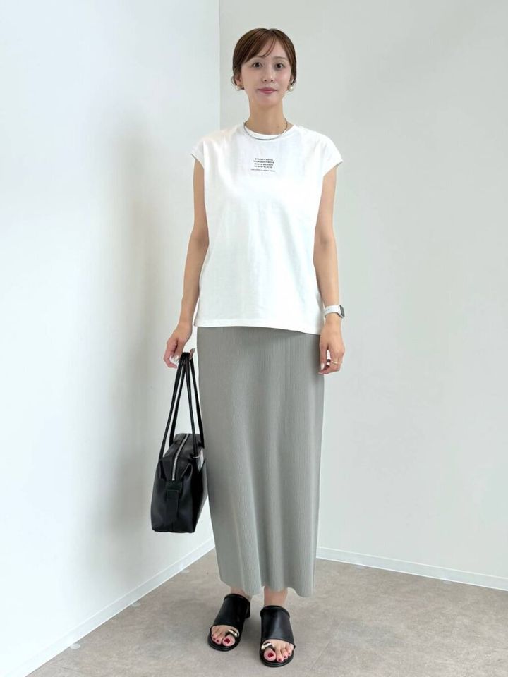 白Tシャツとくすみグリーンナロースカートの女性