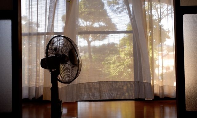 夏のおうち時間 扇風機がカーテンを揺らす夏の夕方