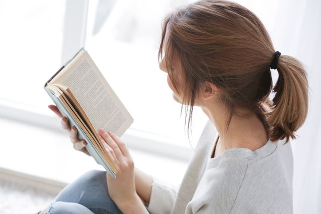 家で読書する女性