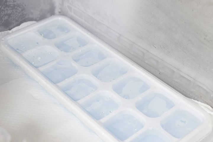 水を八分目まで入れたアイストレーが冷凍庫の棚に置かれている様子
