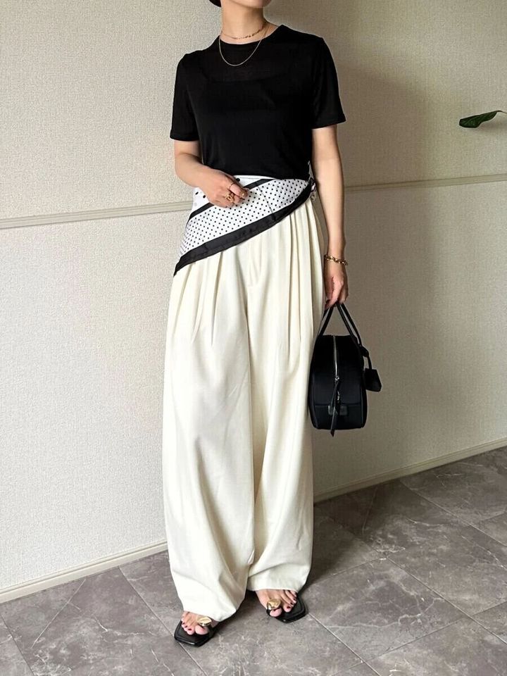 黒シアーTと白パンツにスカーフを巻いた女性