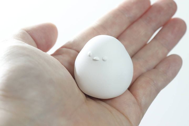 手のひらに乗せた白いシマエナガ型の珪藻土の表側
