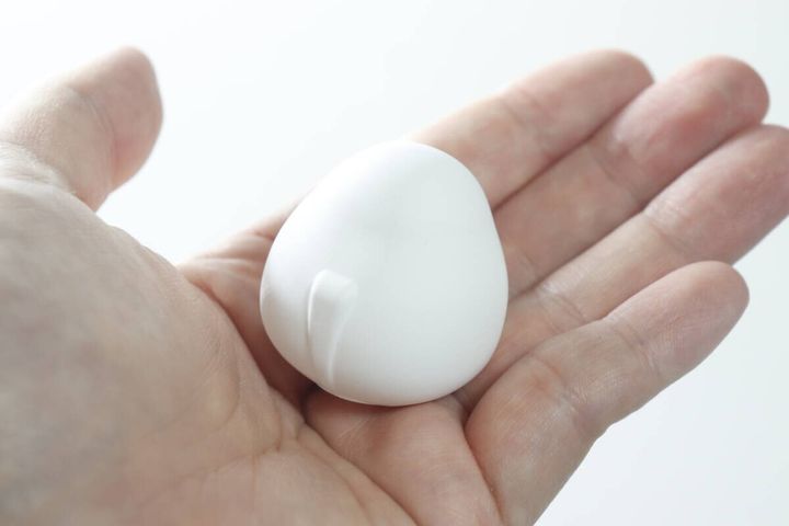 手のひらに乗せた白いシマエナガ型の珪藻土の裏側