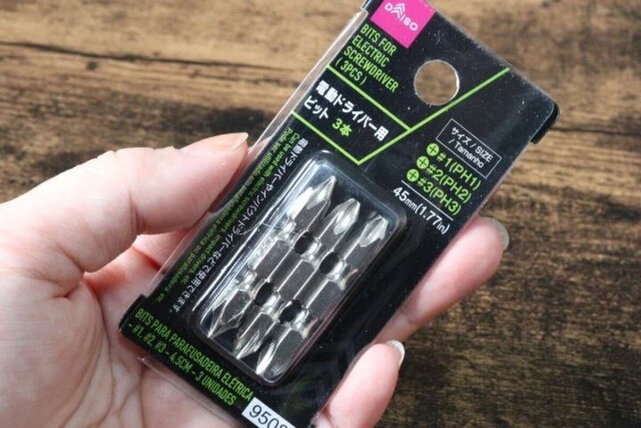 女性の手が電動ドライバー用ビットのパッケージを持つ