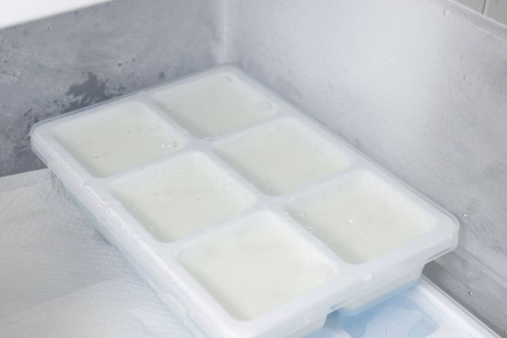 牛乳を注ぎ入れた製氷皿が冷凍庫の棚に置かれている