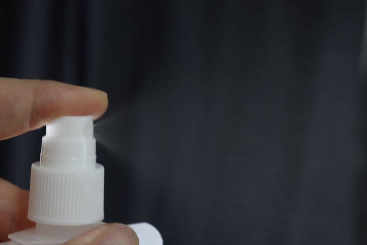 指でパウチ容器のスプレー部分を押しミストを噴射している