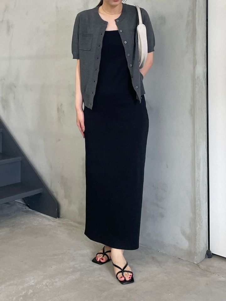 黒のタイトなロングワンピースにチャコールグレーの半袖カーディガンを羽織り、黒いストラップサンダルを合わせた女性の全身
