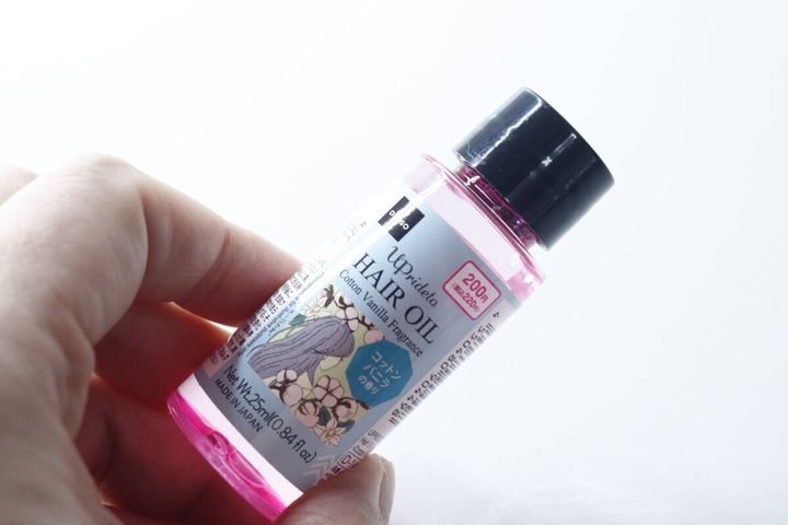 手のひらにコットンバニラの香りのヘアオイルを持っている