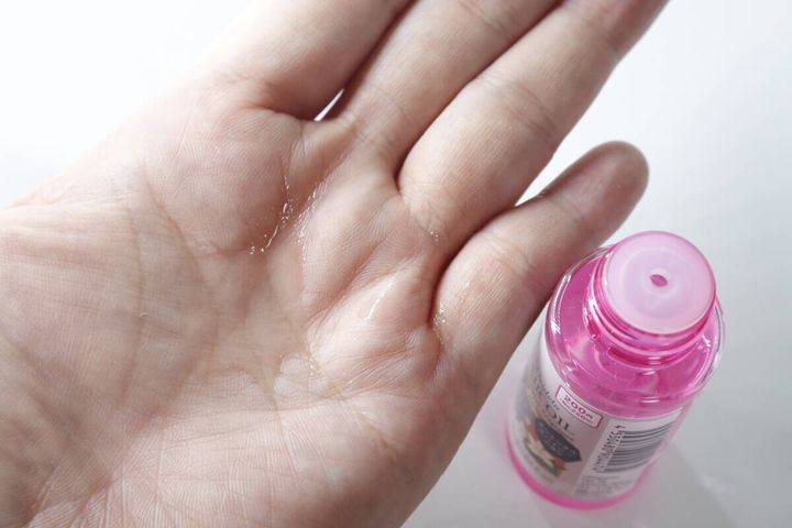 手のひらに透明なヘアオイルが数滴出されている様子