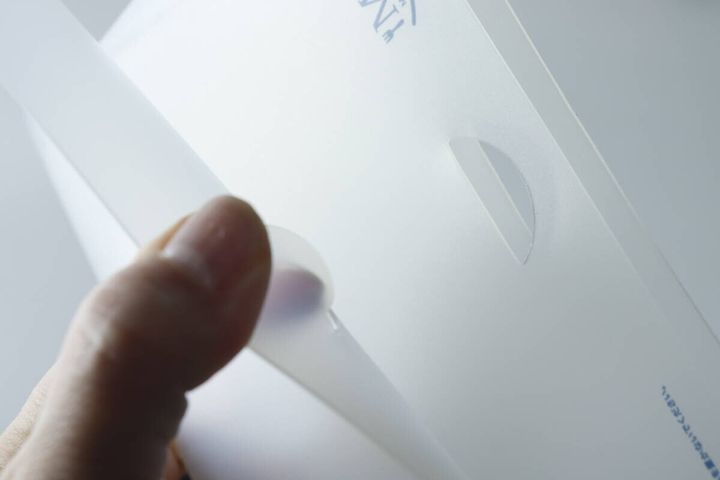 Lサイズのまな板を指で折りたたんで引っ掛け部に固定している様子