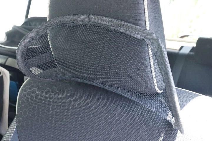 車の座席ヘッドレストに装着された黒いメッシュのバックレスト